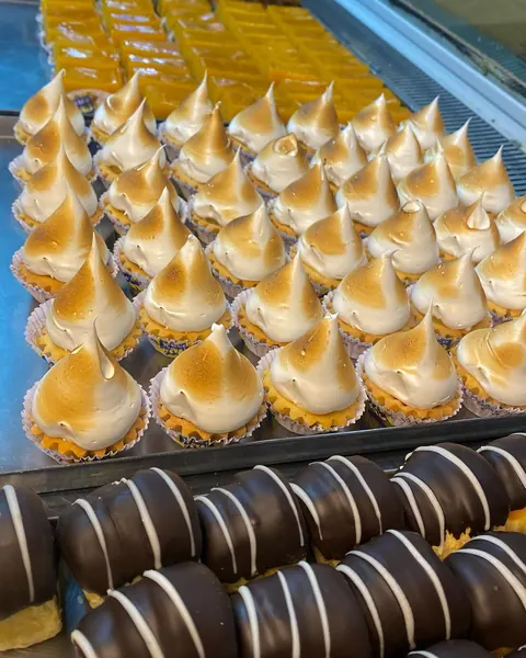 Merenguitos dorados y masitas bañadas en chocolate en la vitrina